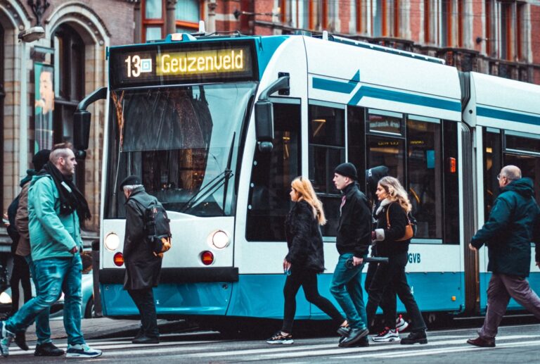 Mensen stappen in tram met bestemming Geuzenveld. Nederlandse taal lezen, spreken, verstaan en begrijpen B1 niveau NT2. Nederland voor inburgeraars Nedercommunicatie levert docent Nederlandse taal in Brabant Etten Leur, Raamsdonkveer, Werkendam, Kaatsheuvel, Dongen, Oosterhout, Raamsdonkveer, Woudrichem, Zundert, Sprundel, Moerdijk, Wagenberg Baarle Hertog, Breda Teteringen, Rijsbergen, Ulvenhout, Gilze Rijen, Chaam, Dorst en Roosendaal.